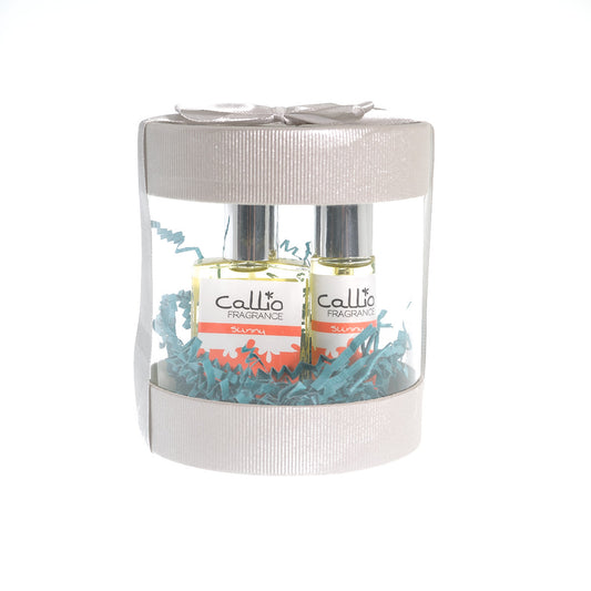 Image of a one-ounce bottle of fragrance with a travel-size bottle, both placed in a silver cylinder gift box.