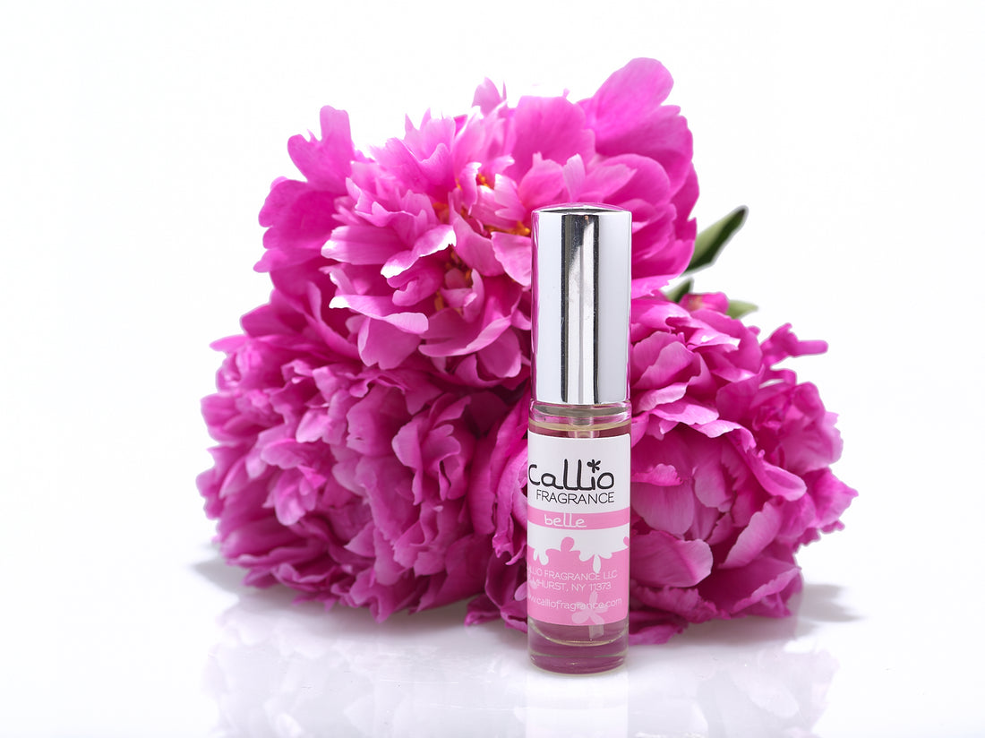 Belle Travel Perfume with three pink peonies on a white background.