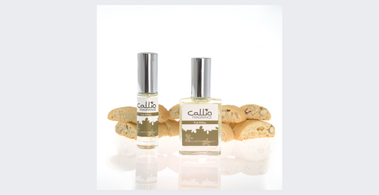Picture of Tessa one-ounce bottle and travel-size perfume spray on a white background with almond biscotti cookies in the background.