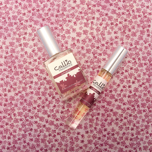 Amelia one-ounce perfume and travel perfume on a pink floral background.