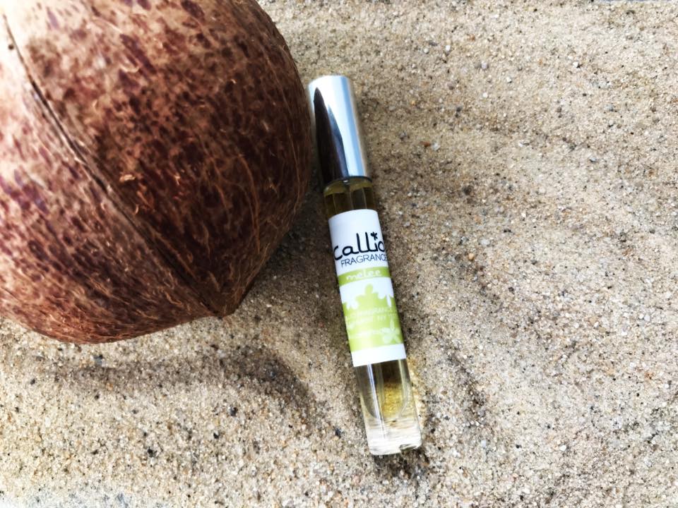 MeleeTravel Perfume on sand with a coconut.