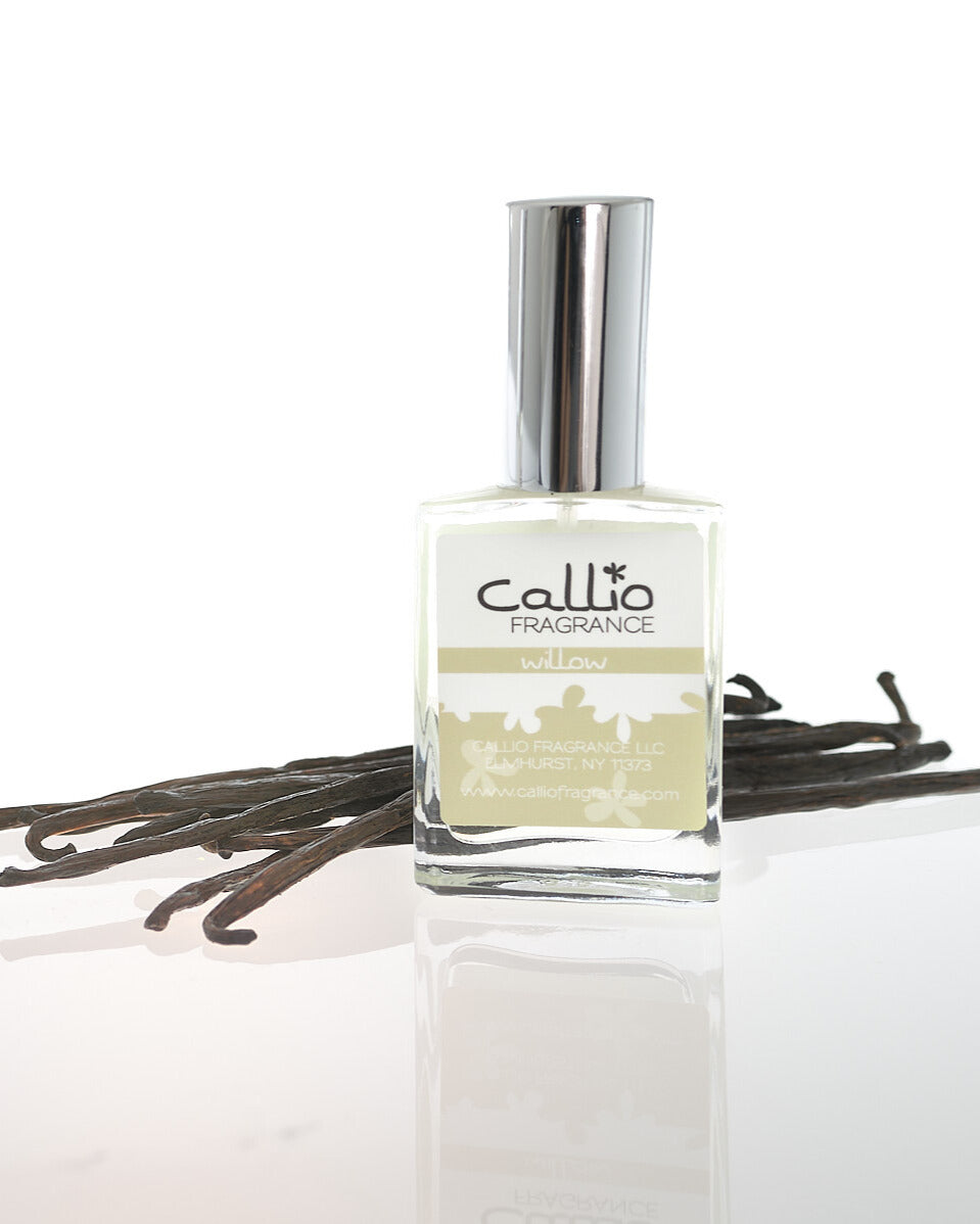 Image of a one-ounce bottle of Willow Perfume by Callio Fragrance on a white background with vanilla beans.