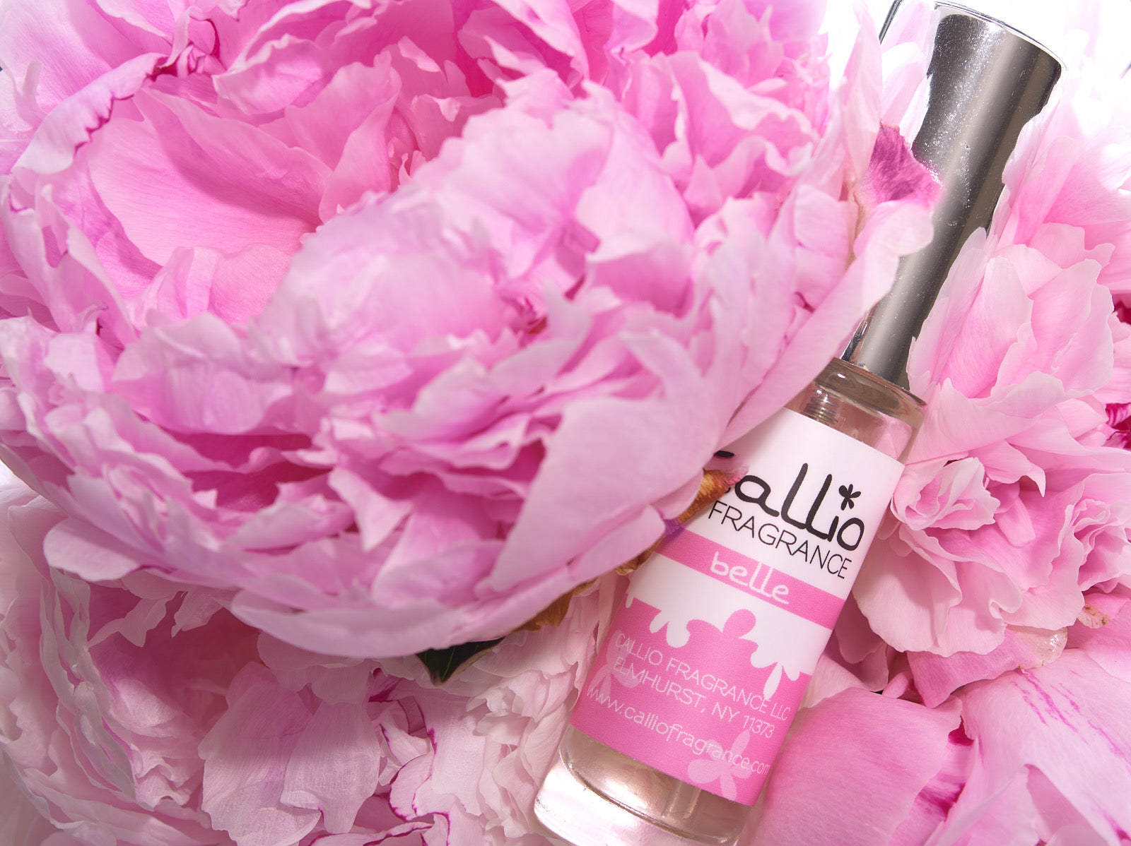 Belle Travel Perfume Spray with pink peonies.