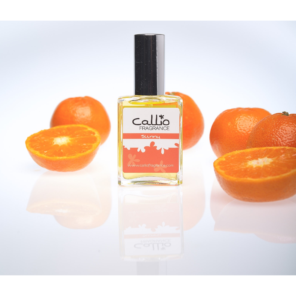 Sunny Perfume 1 oz bottle on a white background with 4 whole mandarin oranges and one sliced in half - Callio Fragrance